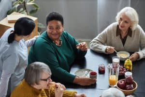 Friendly group of seniors enjoying breakfast together, promoting community and social support services from HelpAlong Pty Ltd.